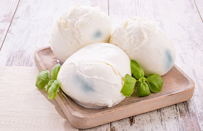 Immagine di una mozzarella che presenta delle striature blu dovute a Pseudomonas fluorescens, un microrganismo non patogeno, che promuove l'articolo del blog della business unit Food