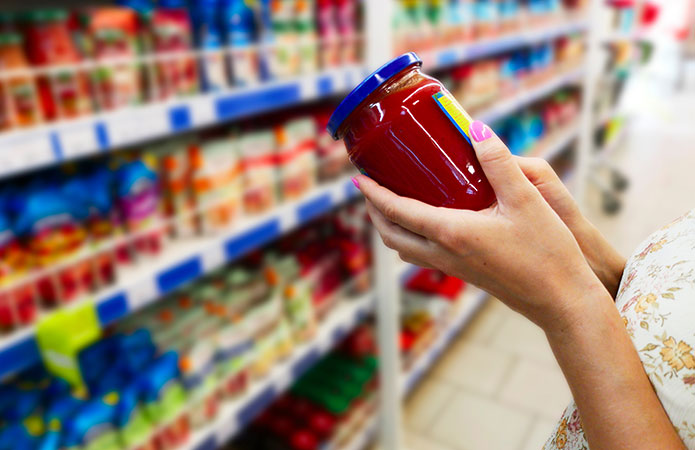 Immagine di una persona che tiene in mano un barattolo di pomodoro che rappresenta attenzione all'etichettatura alimentare