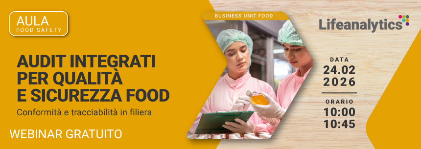 Immagine di due tecnici di laboratorio in camice, guanti e cuffie per capelli che osservano un prodotto alimentare imbottigli